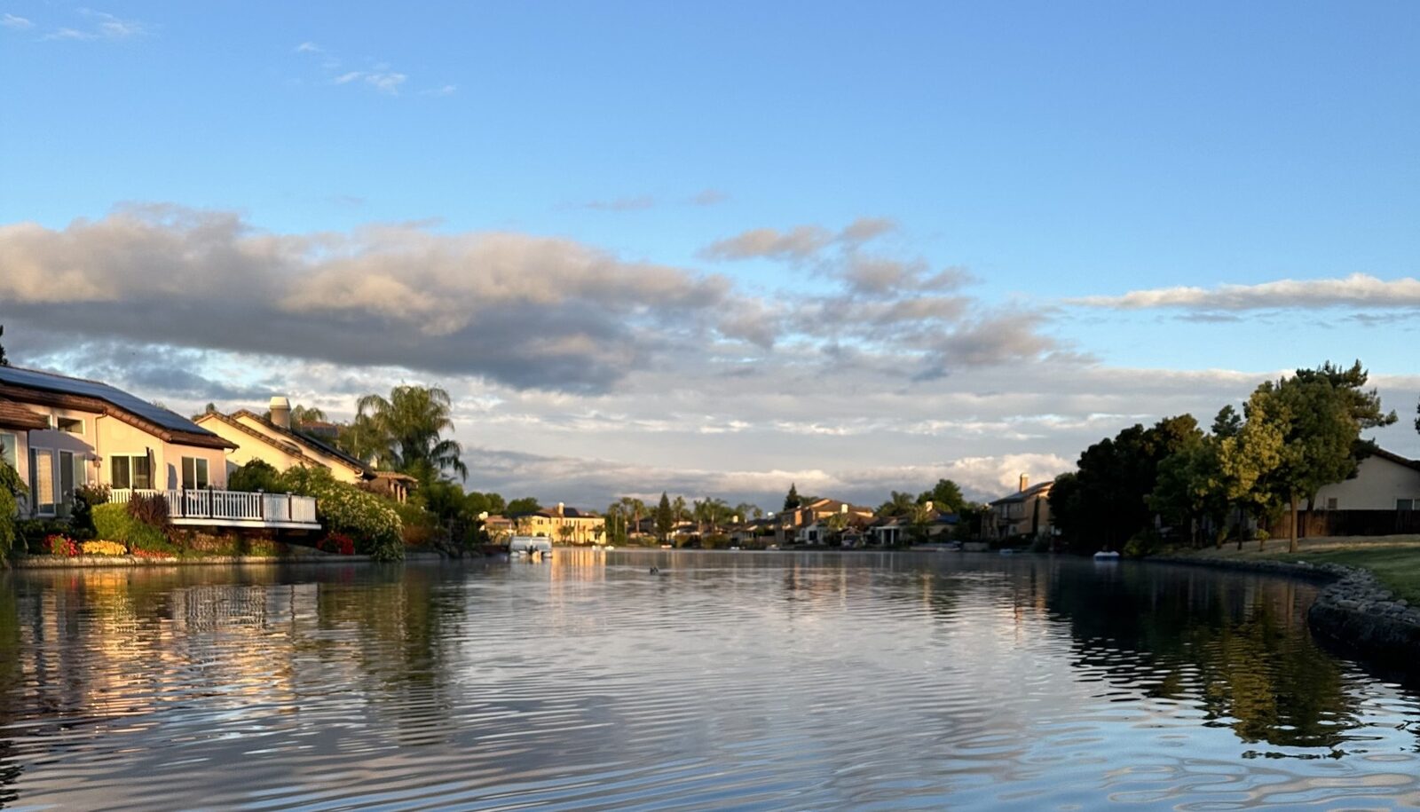 Lakefront home community in California at sunset, representing the range of coverage HMD Insurance Center arranges